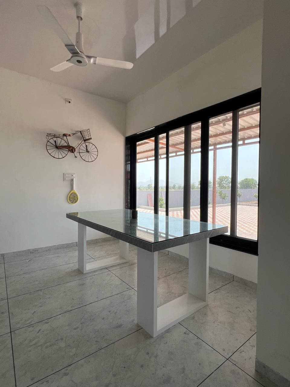 Black-framed PVC windows opening onto a bright patio.
