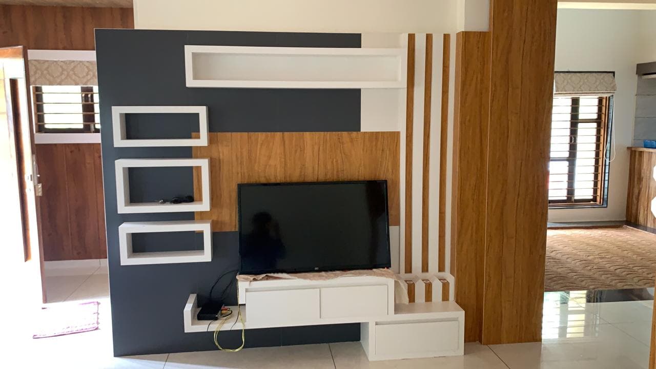Charcoal and wood TV entertainment wall with floating shelves.
